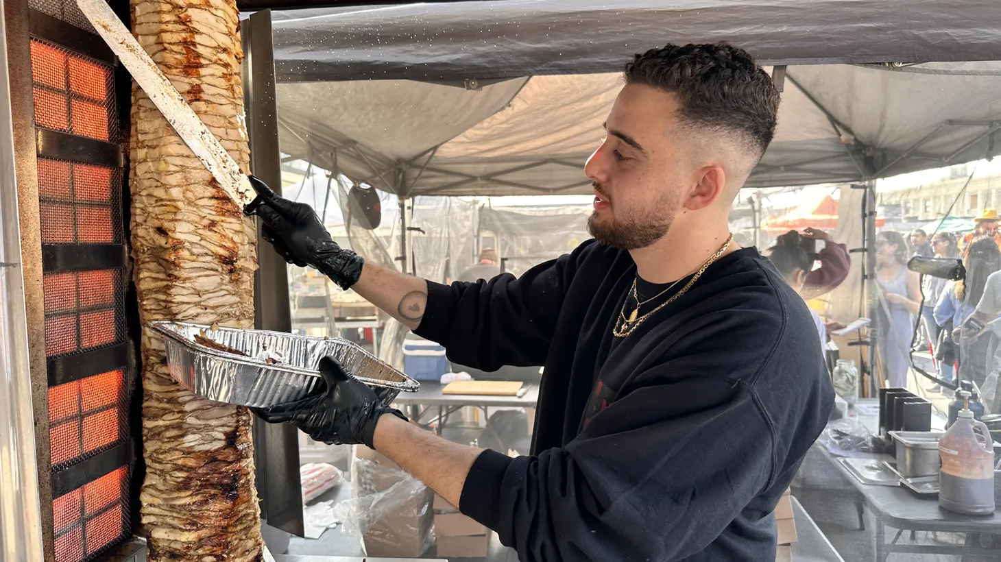 Yazeed Soudani shaves chicken shawarma for hungry customers at Smorgasburg LA.