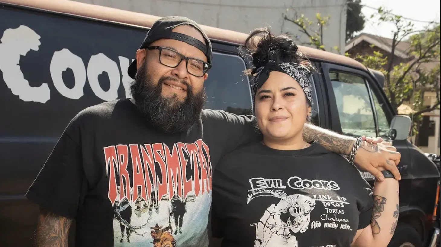 Alex Garcia and Elvia Huerta stand in front of the Evil Cooks van with its distinctive logo.