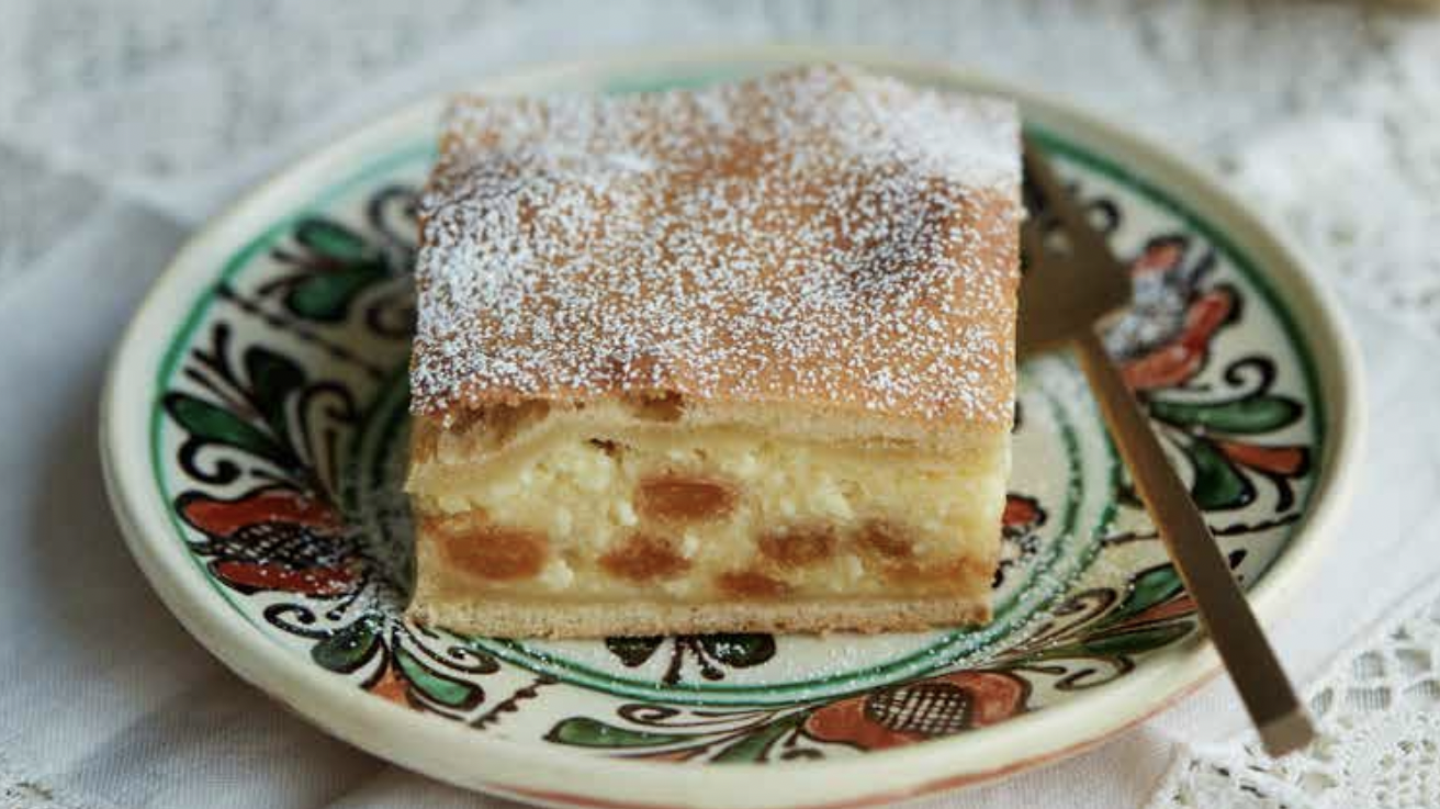 Apples and sultanas (golden raisins) are added to a cheese curd plăcintă, or pie, to give texture to this Romanian dessert.