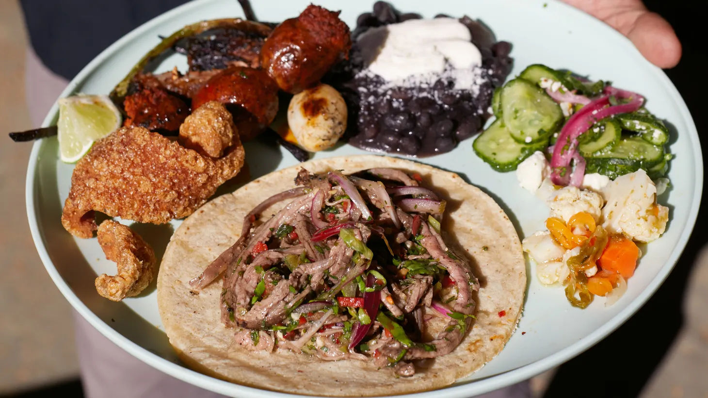 A plate of carne asada is the perfect thing to eat at an asada, a casual grilling party typically held in a backyard or a park.