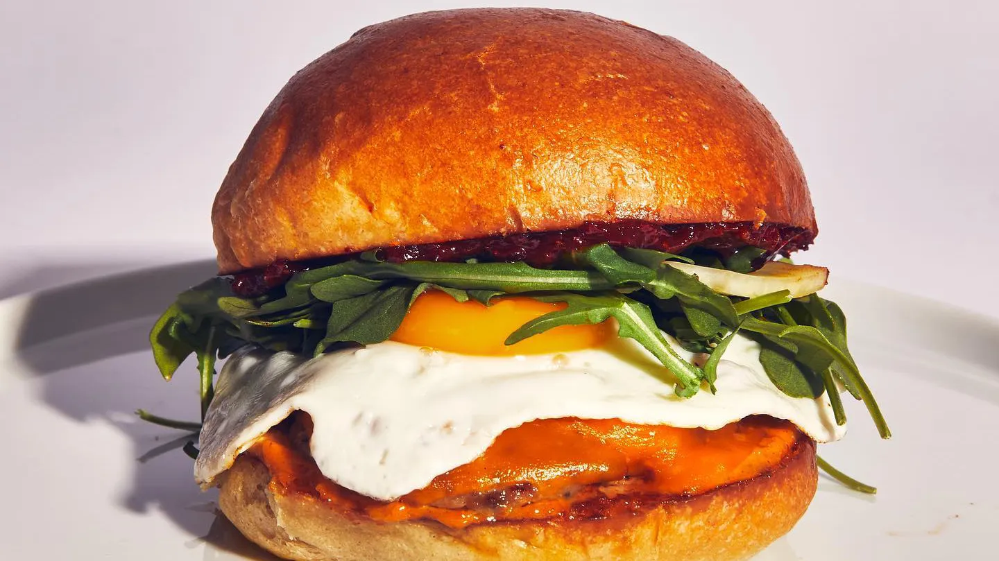 Open Market’s O.M. Breakfast Sandwich is stacked with a housemade sausage patty, egg, arugula, pickled fennel, tomato harissa jam, and paprika aioli.