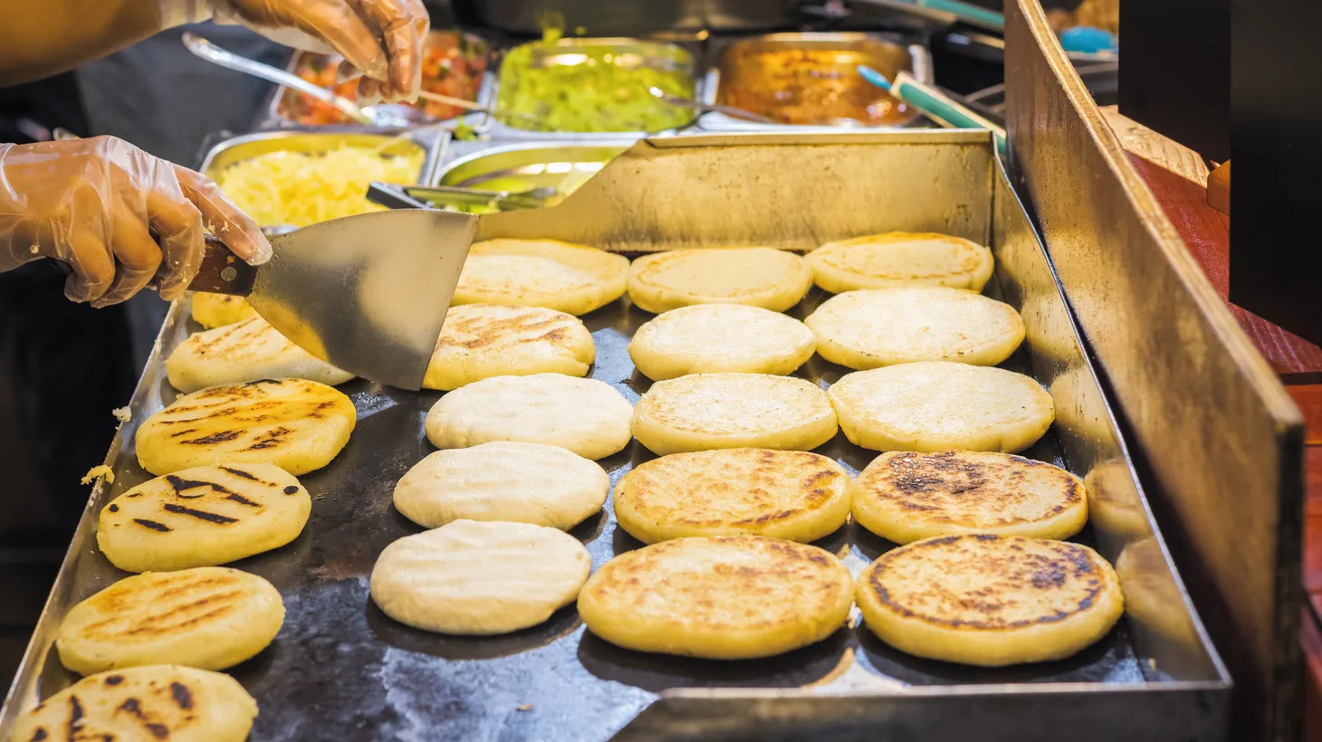 A street vendor's pupusas cook on a portable griddle. With complaints of trash and bad odors, street vendors along the El Salvador Corridor were forced to shut down. Community organizations like the Salvadoran American Leadership and Education Fund (SALEF) are working with vendors facing displacement.