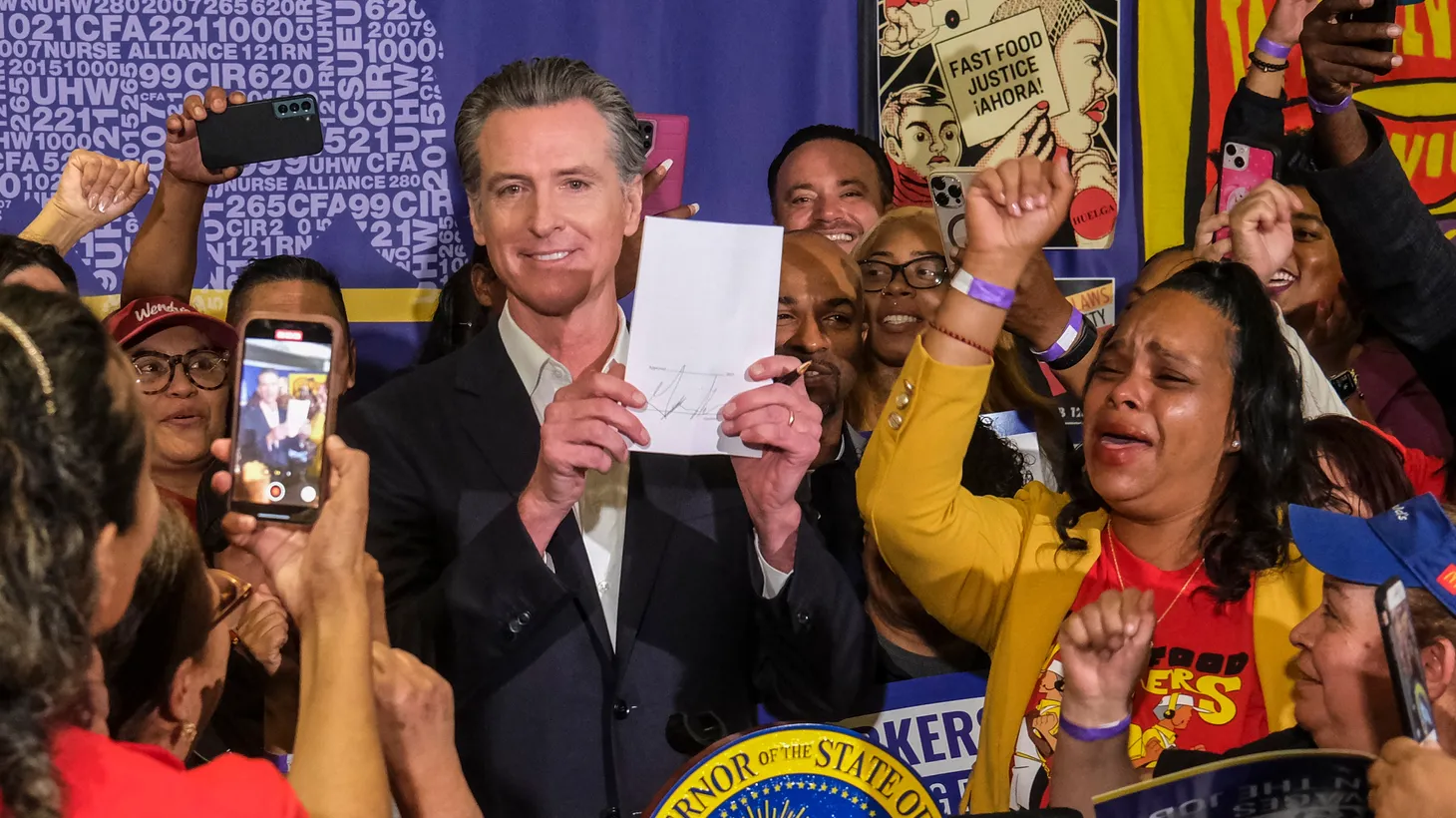 Governor Gavin Newsom signs the fast food bill AB1228 in Los Angeles, on Thursday, Sept. 28, 2023. Starting in April, California's fast food workers will have a minimum wage of $20 per hour under a new law.