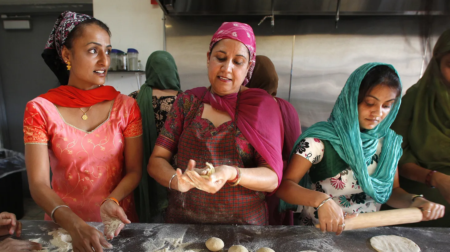 At the gurdwara (Sikh temple) in Oak Creek, Wisconsin, Mandeep Ahuja (left) and Jasbir Dulai (center) make roti (unleavened bread) for the langar, a Sikh traditional community meal.
