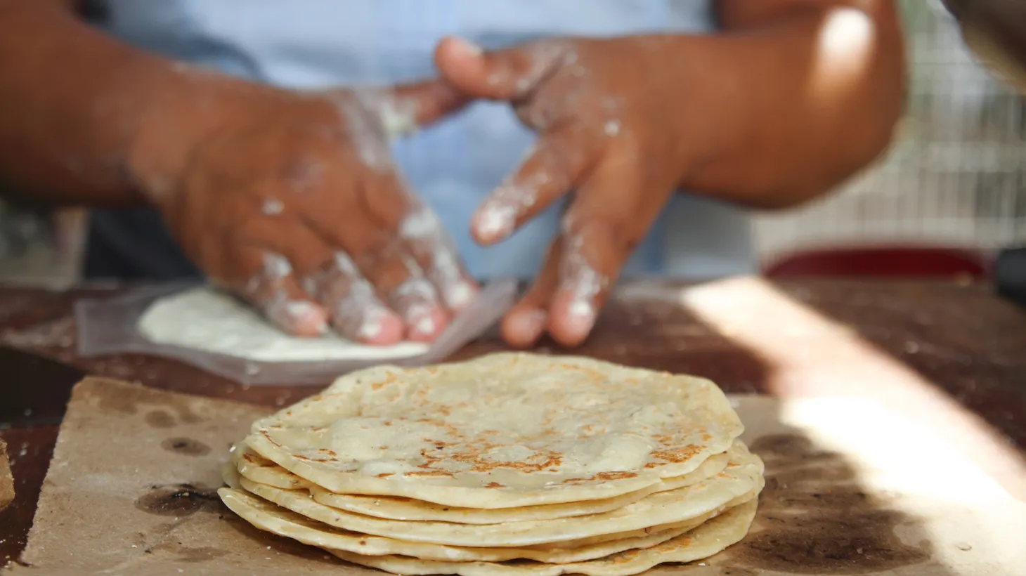 A woman makes classic flour tortillas.