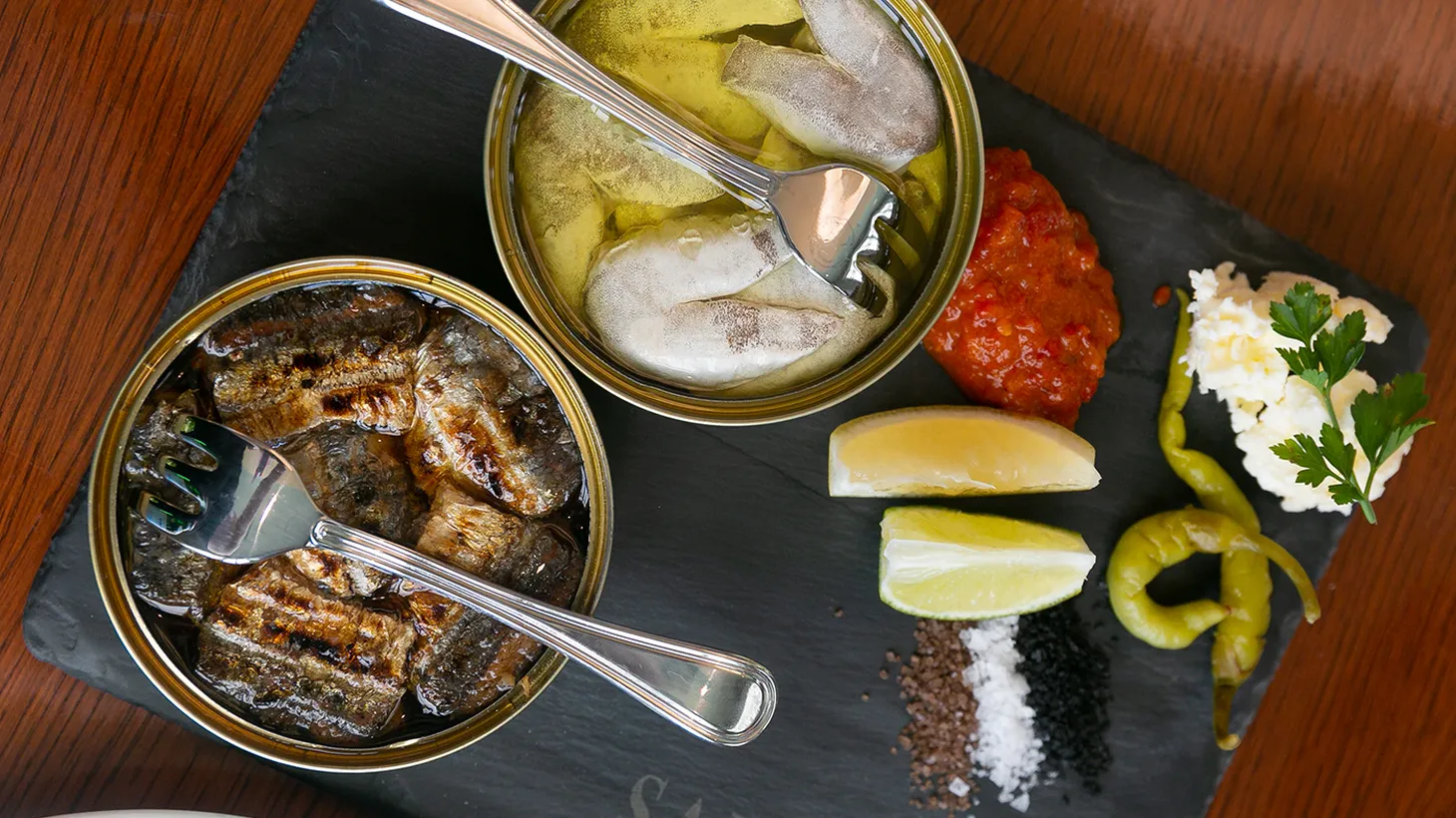 The tinned fish at Saltie Girl is served with salts, butter, lemon, and housemade piquillo pepper jam.