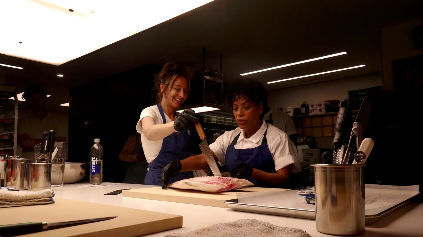Culinary producer Courtney Storer (left) assigned homework, including breaking down a whole branzino, to actress Liza Colón-Zayas, whose character, Tina, was promoted to sous chef in season two of The Bear.