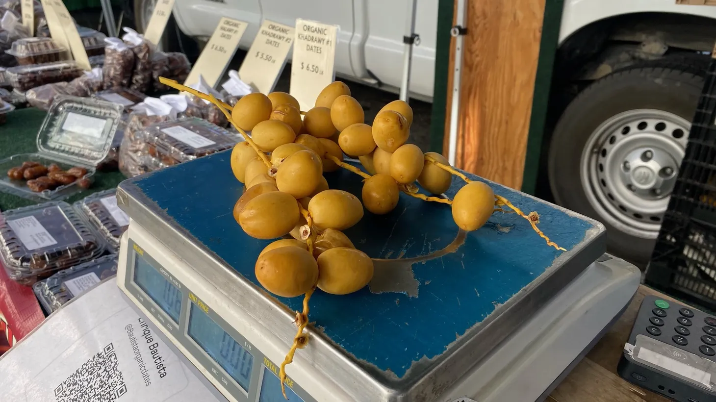 Farmer Alvaro Bautista announces his return to the market with pale yellow sprays of dates.