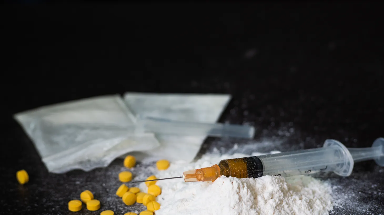 Amphetamine pills, Ketamine powder, plastic baggies of powdery substance along with a syringe needle.