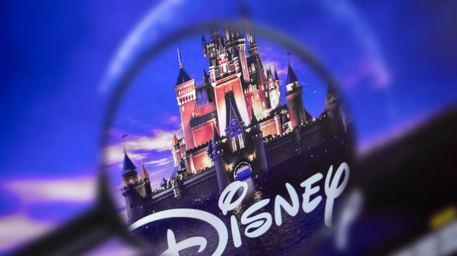 The home page of the Walt Disney Co. website viewed through a magnifying glass.