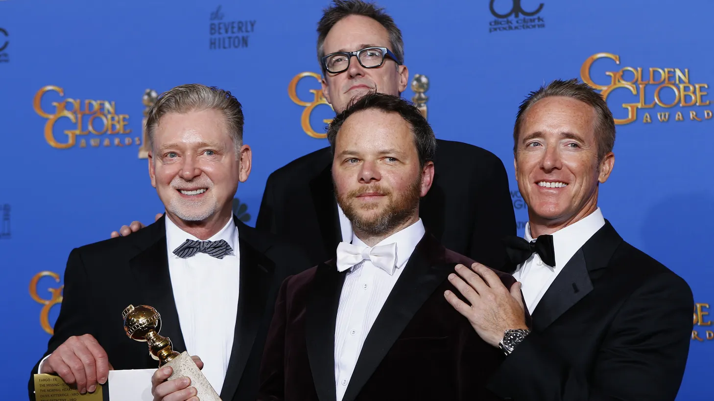Executive producer Noah Hawley (C) holds the award for Best TV Movie or Mini-Series for "Fargo" along with fellow producers Warren Littlefield (L), Adam Bernstein (rear) and Geyer Kosinski (R) backstage at the 72nd Golden Globe Awards in Beverly Hills, California January 11, 2015.