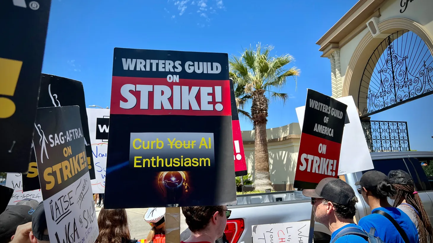 A placard protesting AI, held by a member of the Writers Guild of America (WGA), picketing outside Paramount Pictures with members of the Screen Actors Guild (SAG-AFTRA).