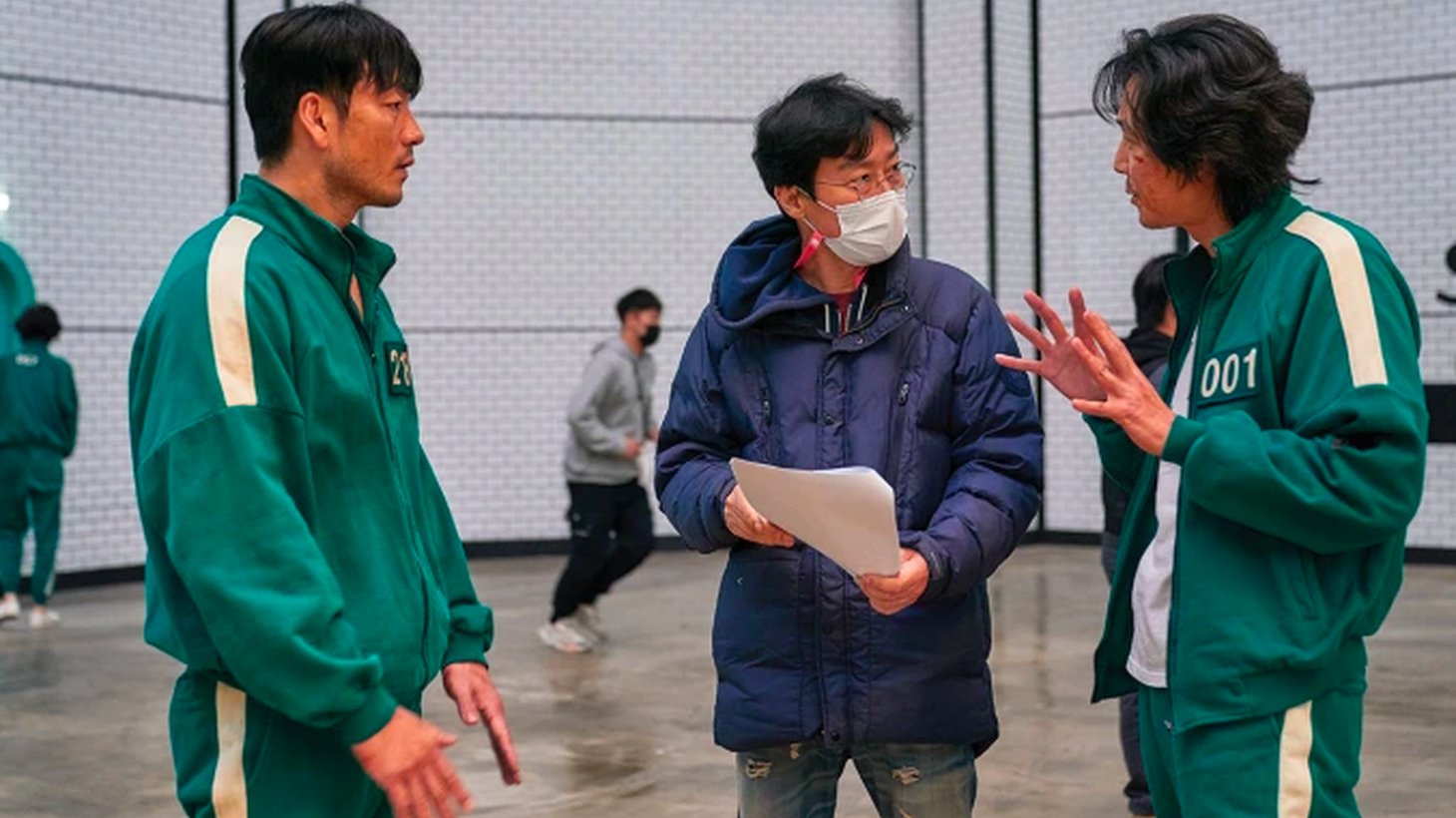 Director Hwang Dong-hyuk (center) works on the set of Netflix’s “Squid Game” with actors Park Hae-soo (left) and Lee Jung-jae.