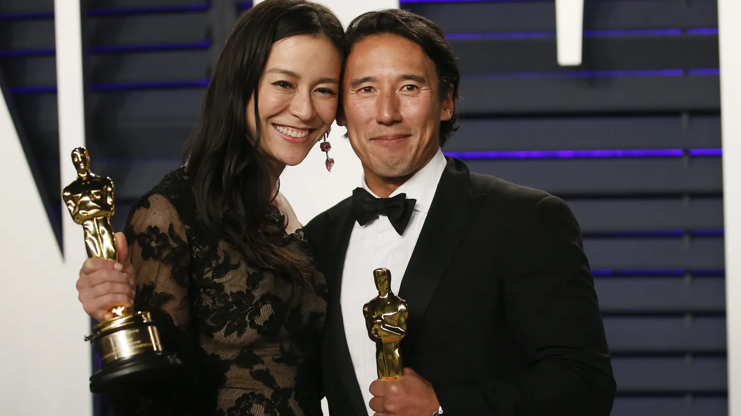 Chai Vasarhelyi (L) and Jimmy Chin hold their award for best documentary feature for “Free Solo” at the Vanity Fair party in Beverly Hills, on February 24, 2019.