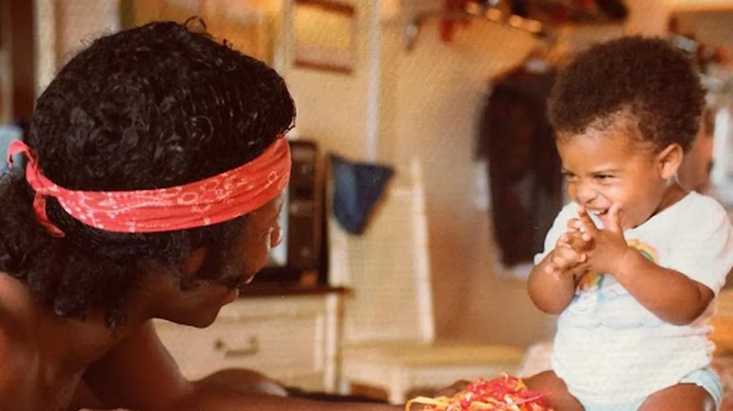 Sly Stone sharing a laugh with baby Novena.