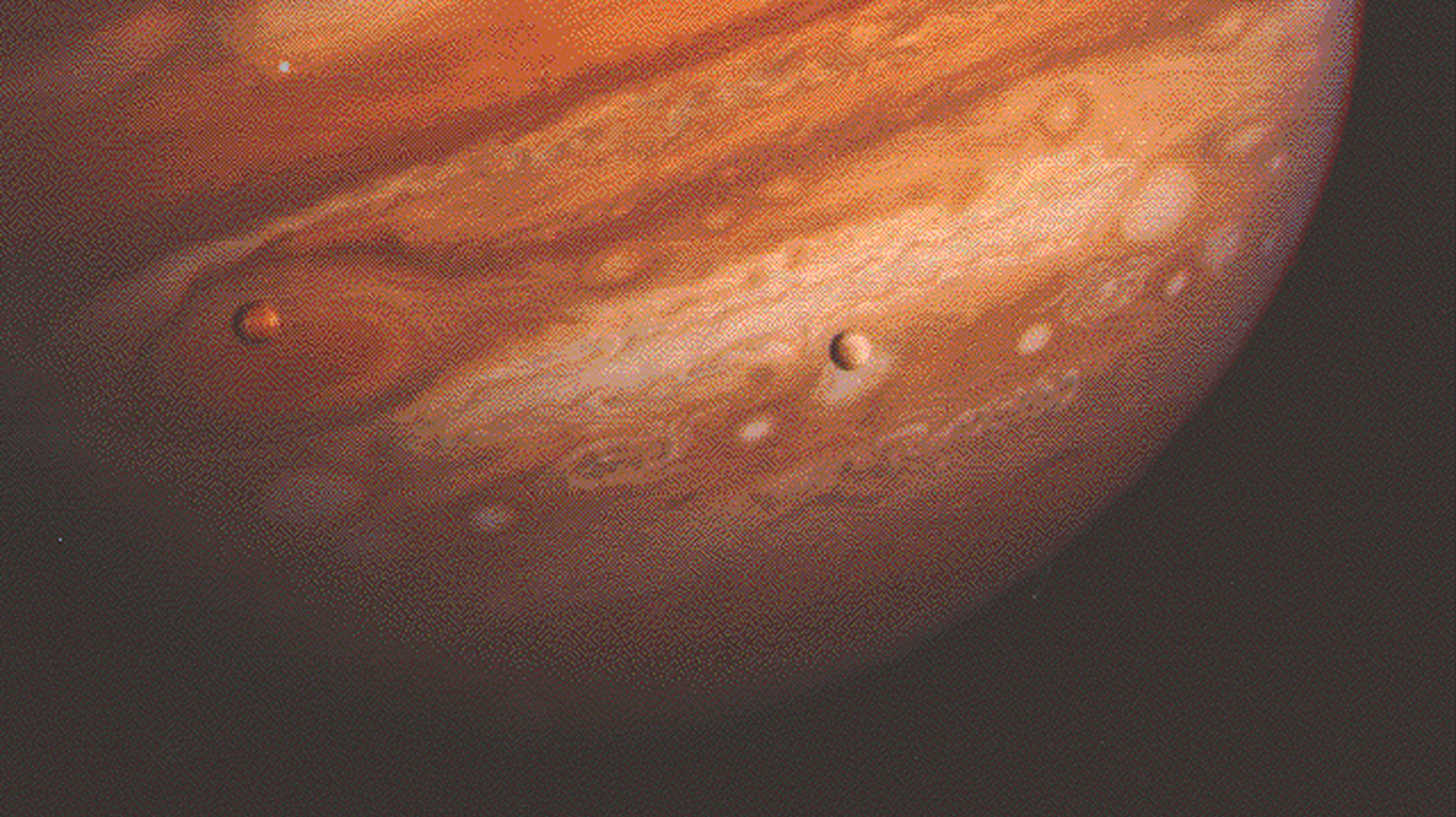 This is an image taken by one of the Voyager spacecraft a few years into its mission to explore the outer planets. It shows Jupiter with some of its moons in the foreground.