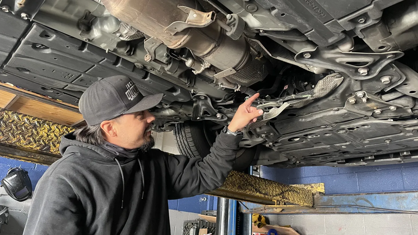 Edward Luna points to the spot where a catalytic converter was cut from a customer’s 2011 Toyota Prius. The Van Nuys shop he runs with his father has seen a constant flow of customers with stolen catalytic converters.