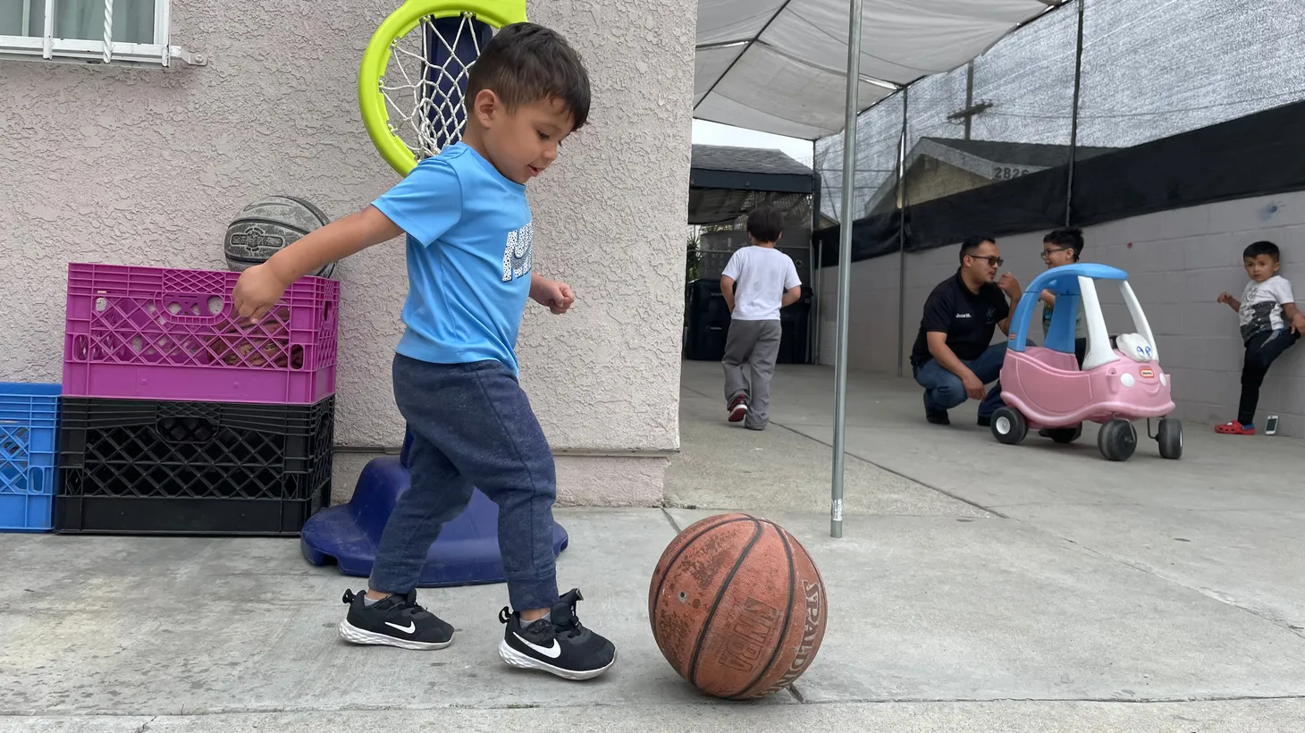 Elijah Rascon shoots hoops during play time at Lorenzo Family Child Care in Boyle Heights. This child care is one of many awaiting promised payments from the state of California to help with pandemic recovery.