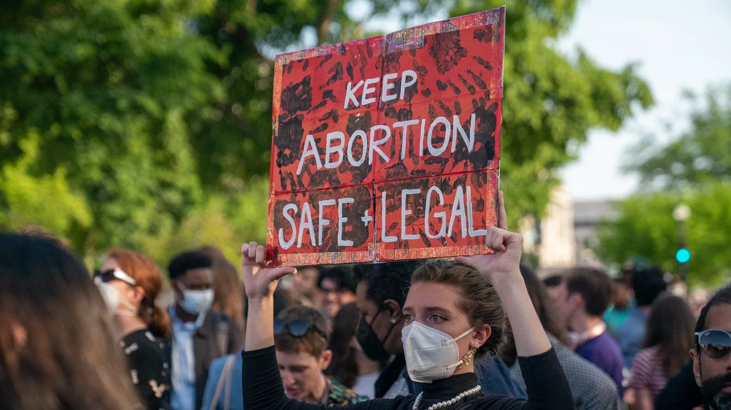 An activist holds a sign that says, “Keep abortion safe and legal.”