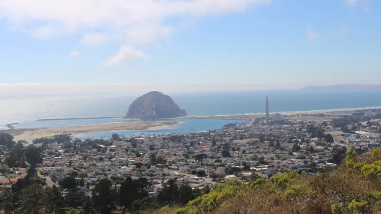 Morro Bay is a small fishing village known for its iconic view of a volcanic rock off the coast. A new project would add about 200 floating wind turbines in the distance.