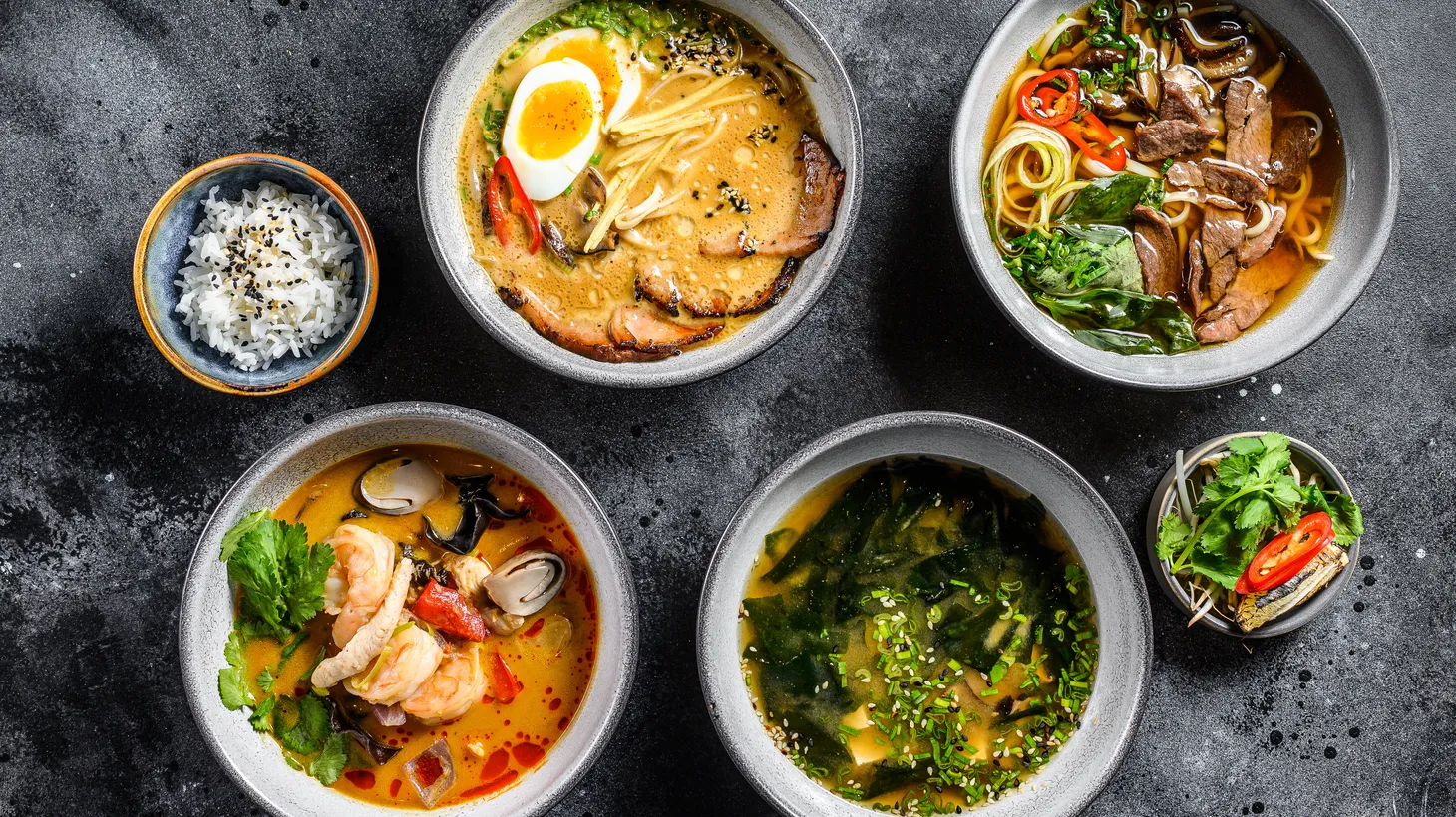 Miso, ramen, tom yam, beef pho are displayed on a table.
