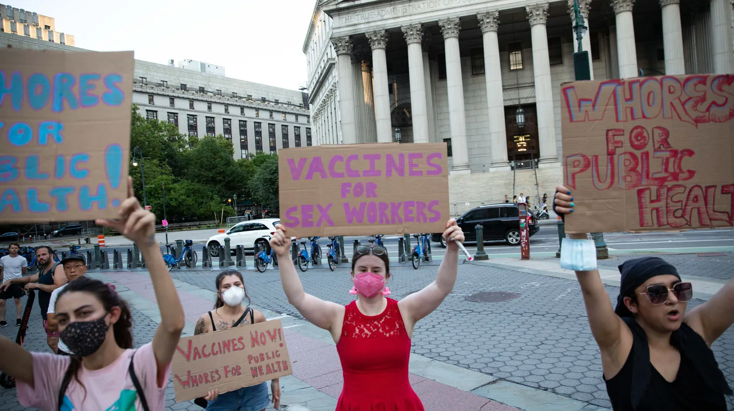 Activists hold signs that say “vaccines for sex workers” and “whores for public health,” at Foley Square in New York City, NY on July 21, 2022. They’re urging federal and state governments to take immediate action to make the monkeypox vaccine available for all those at risk, particularly the LGBTQ+ community and sex workers.