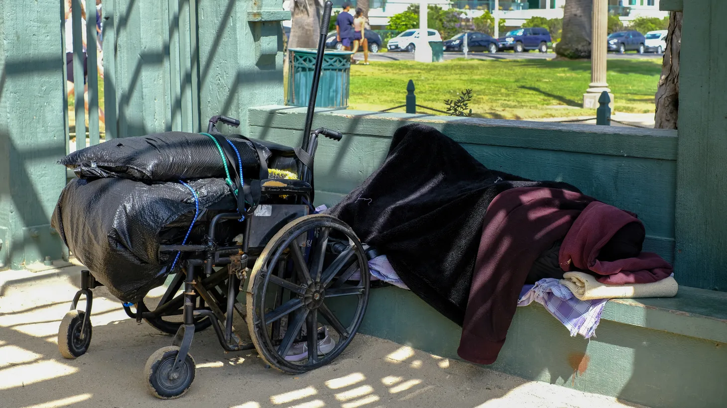 An unhoused person sleeps on a bench in Palisades Park, Santa Monica, July 25, 2022. “Everything starts with outreach — finding an individual with severe mental illness who is living on the streets, building a bond with them, building a therapeutic alliance, or relationship of trust,” says Dr. Shayan Rab, a street psychiatrist with the Los Angeles County Department of Mental Health.