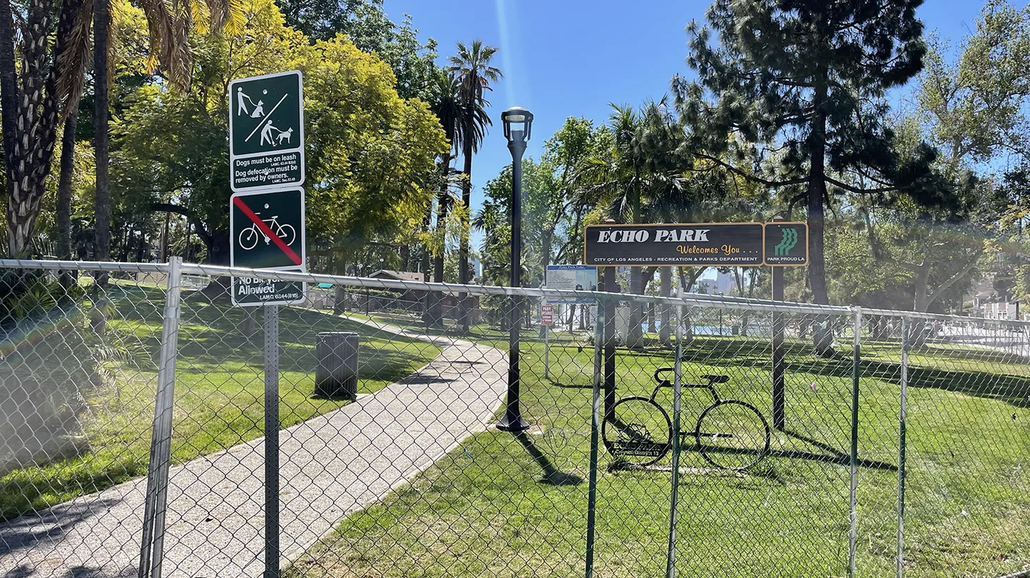 The chain link fence remains at Echo Park Lake in March 2022, one year after it was erected in an effort to clear a large homeless encampment.