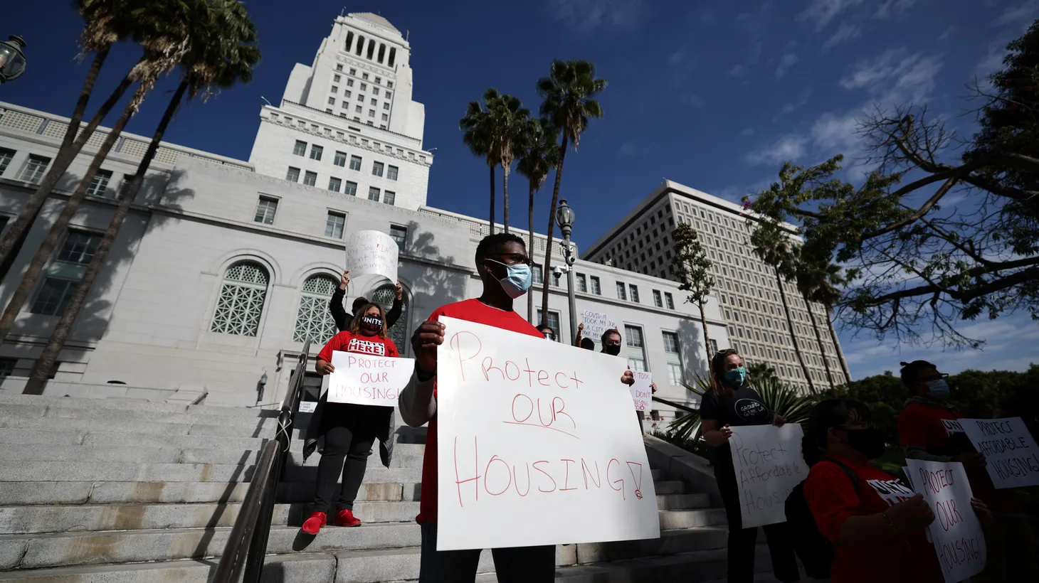 Activists outside LA City Hall hold signs that say, “Protect our housing!” November 12, 2020.