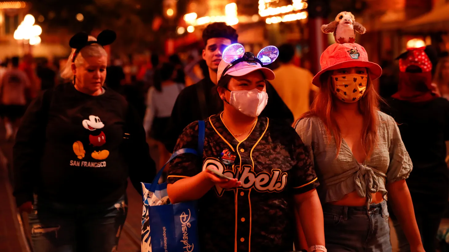 Visitors wearing face protective masks walk on Main Street at Disneyland Park in Anaheim, California, U.S., July 24, 2021.
