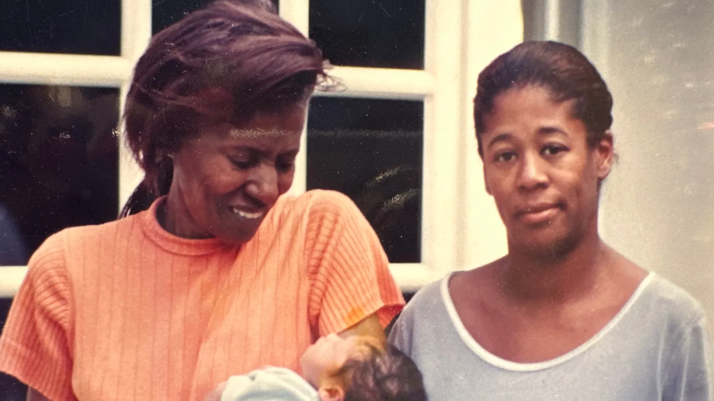 Alice Coltrane (left) holds her baby grandson Nicolas, as she stands next to her daughter Michelle (right), in front of their home in Woodland Hills in August 1998.