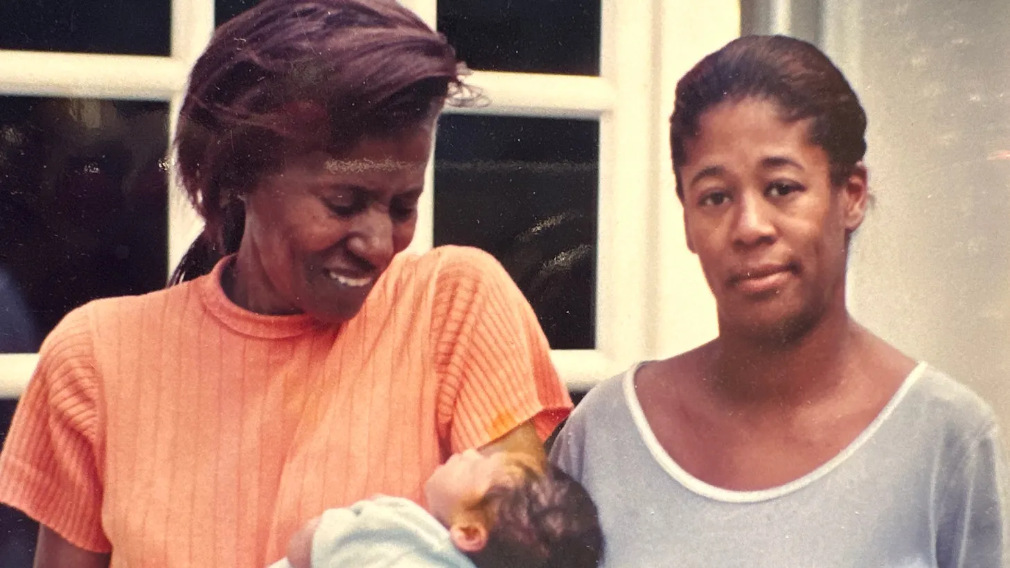Alice Coltrane (left) holds her baby grandson Nicolas, as she stands next to her daughter Michelle (right), in front of their home in Woodland Hills in August 1998.