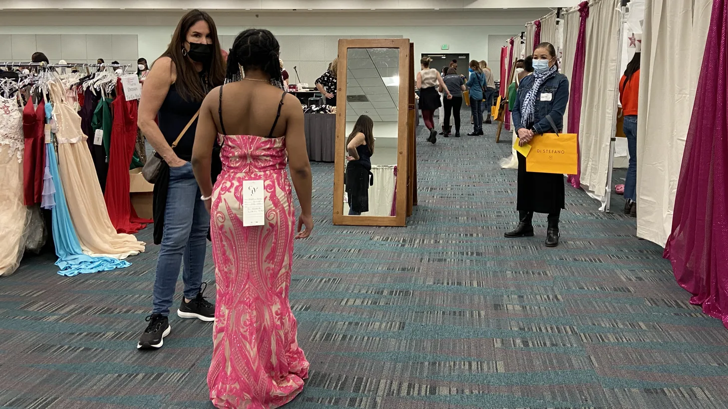 Volunteers help a Glamour Gowns participant find the perfect prom dress in 2022.