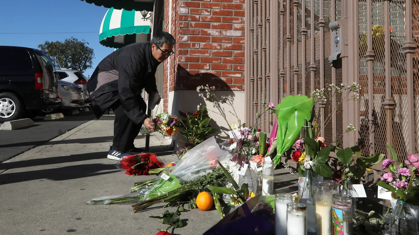 A man lights a candle at the entrance of the Star Ballroom Dance Studio after a mass shooting during Lunar New Year celebrations in Monterey Park, California, U.S. January 23, 2023.
