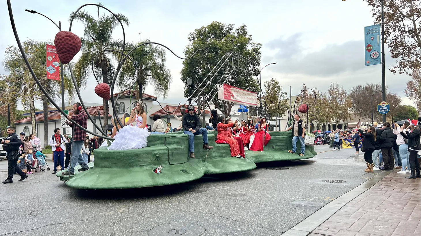 Downey’s in-progress float is seen in the city’s Christmas parade. Riding on it: young women crowned queens and princesses in a local fundraising pageant. The finished float will appear on January 2, 2023 during the Pasadena Tournament of Roses parade.