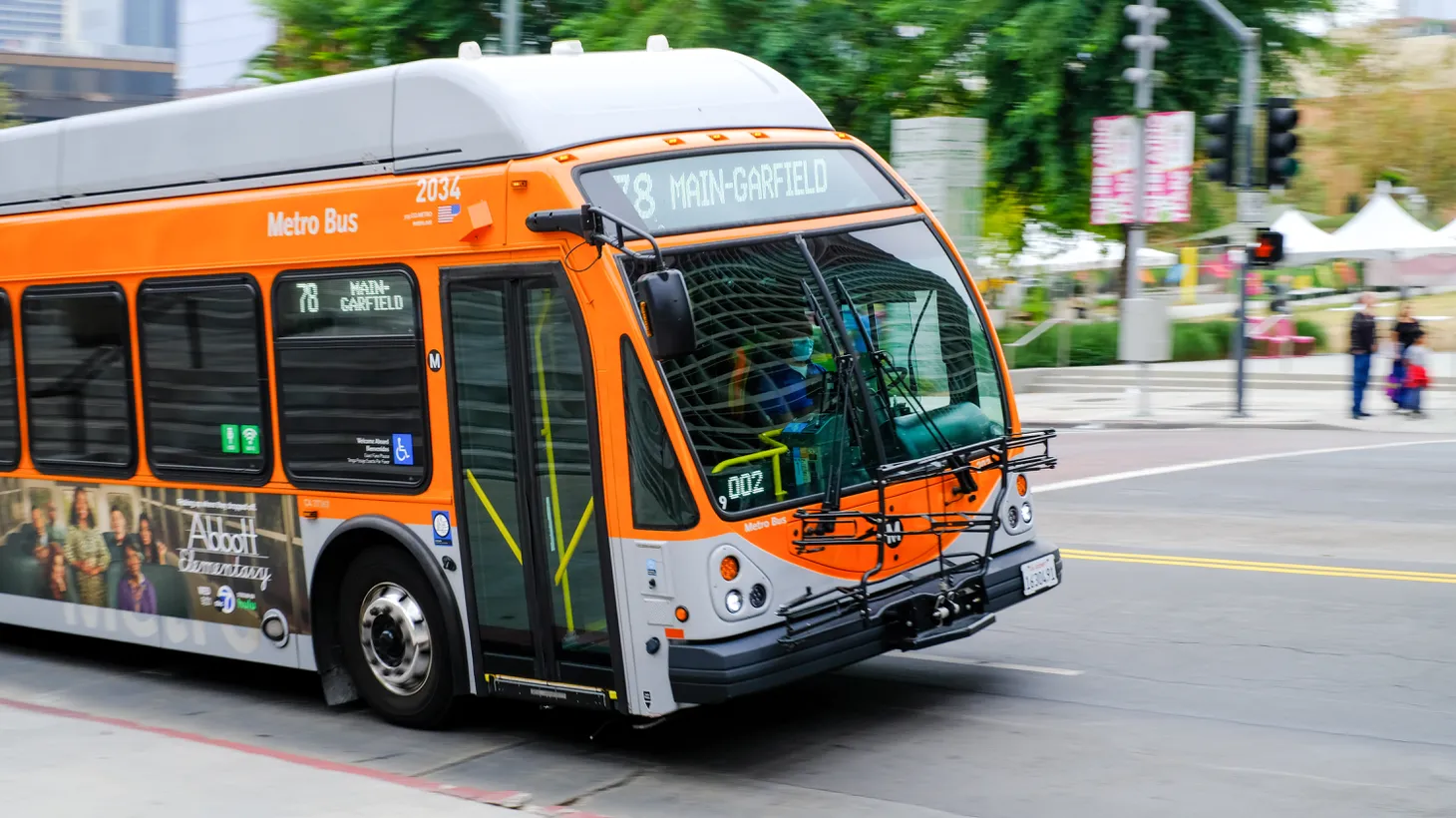 A Los Angeles Metro bus speeds by LA City Hall.