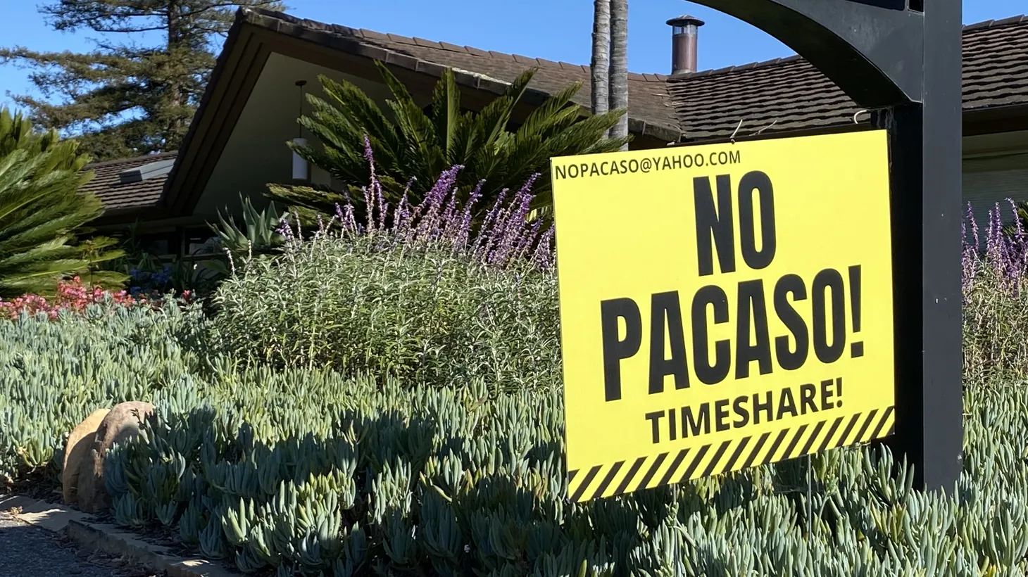 Bright yellow signs declare opposition to real estate startup Pacaso in Santa Barbara, one of many California communities wrestling with how to regulate the company.