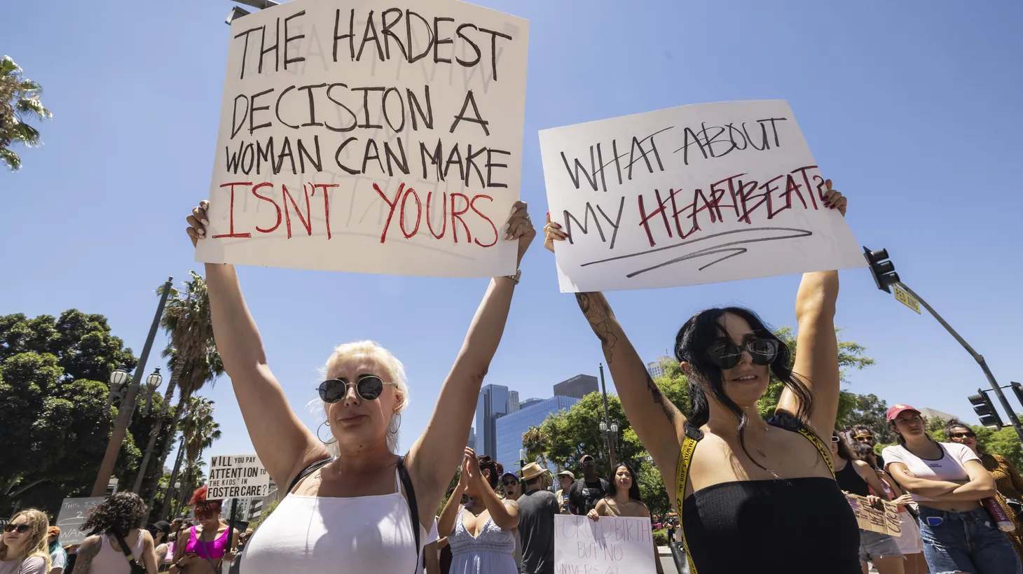 Activists in Los Angeles hold signs that say, “The hardest decision a woman can make isn’t yours” and “What about my heartbeat?” Photo taken June 25, 2022.