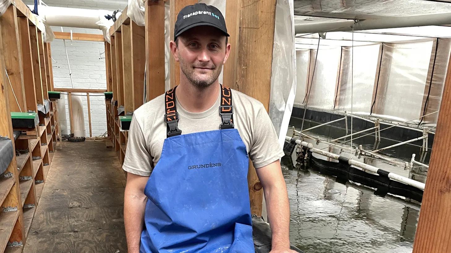 TransparentSea farms founder Steve Sutton poses next to a large tank of Pacific whiteleg prawns at his shrimp farm in Downey.