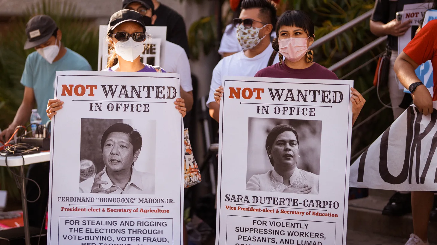 Activists hold “not wanted in office” posters of Ferdinand "Bongbong" Romualdez Marcos Jr. and Sara Duterte-Carpio outside the Philippine Consulate on Wilshire Blvd. on July 24, 2022.