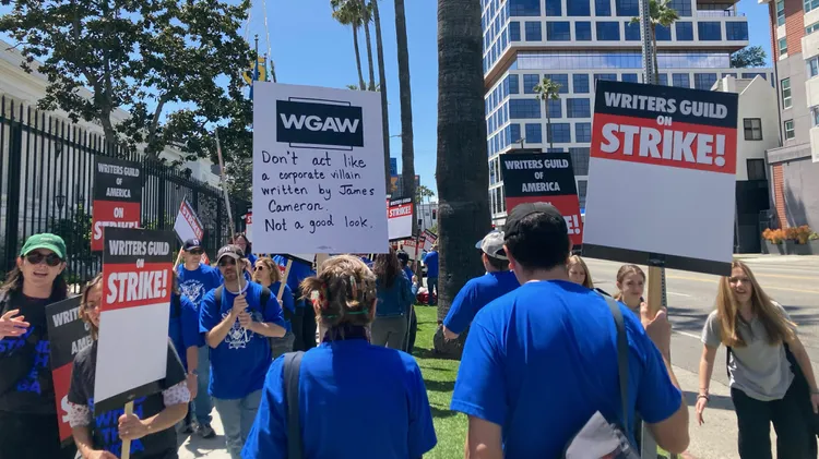 More than 11,000 film and TV writers hit the picket lines today to demand higher pay, better working conditions, and more. KCRW hears from a set dresser, plus a stunt driver and actor.