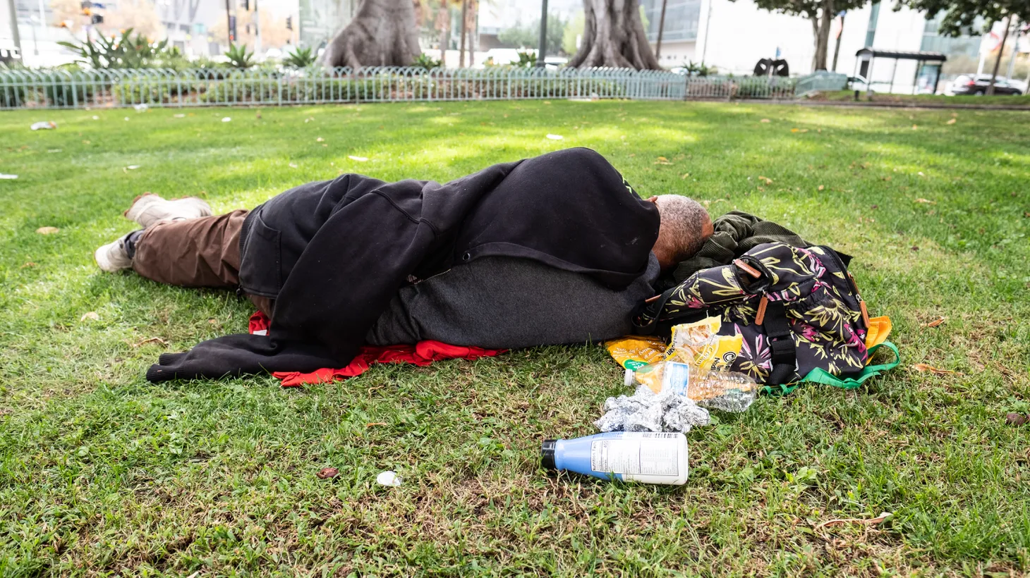 An unhoused person lies on the grass with their food and beverage containers. “We want to see the successful homeless count not just for our efforts here in the city, but also [for] what's happening in the San Gabriel Valley,” says Duarte Spokesperson Victoria Rocha.