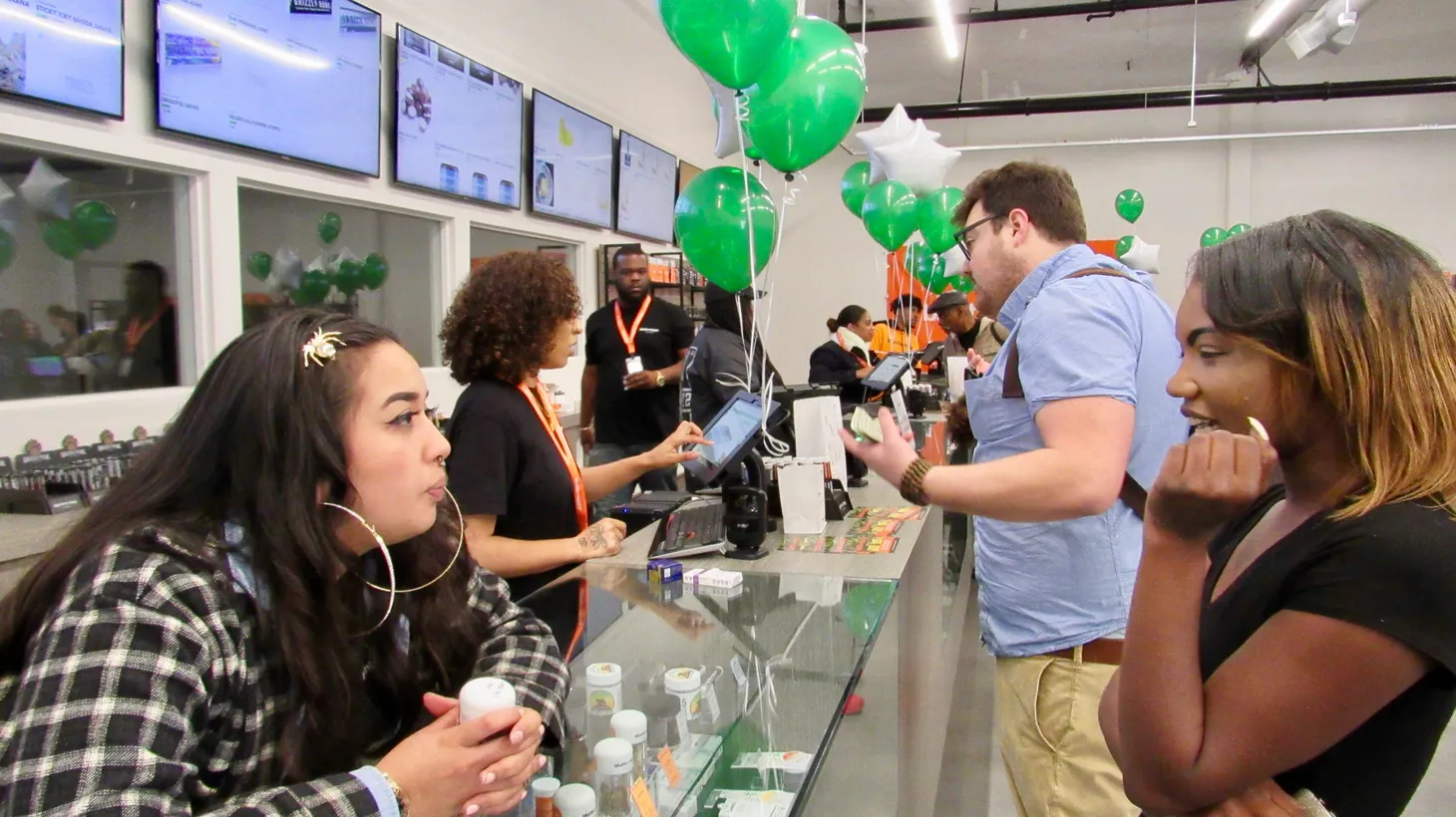 A “budtender” speaks to a customer at the grand opening of the Blunts and Moore dispensary in Oakland, CA.
