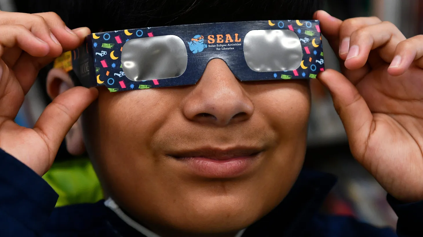 David Martinez, 12, tries on the free pair of solar eclipse glasses that he received at the Cumberland County Library in Bridgeton, NJ on Tuesday, April 2, 2024.