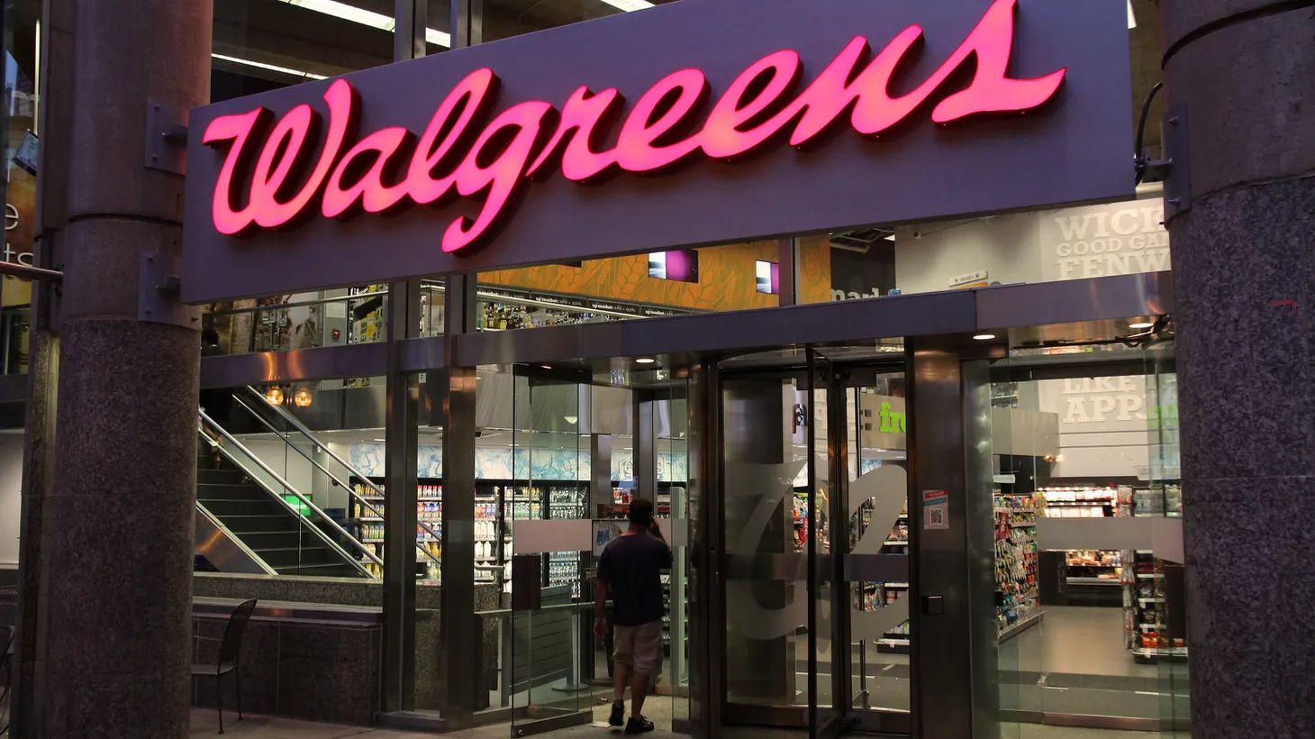 People walk by a Walgreens, owned by the Walgreens Boots Alliance, Inc.