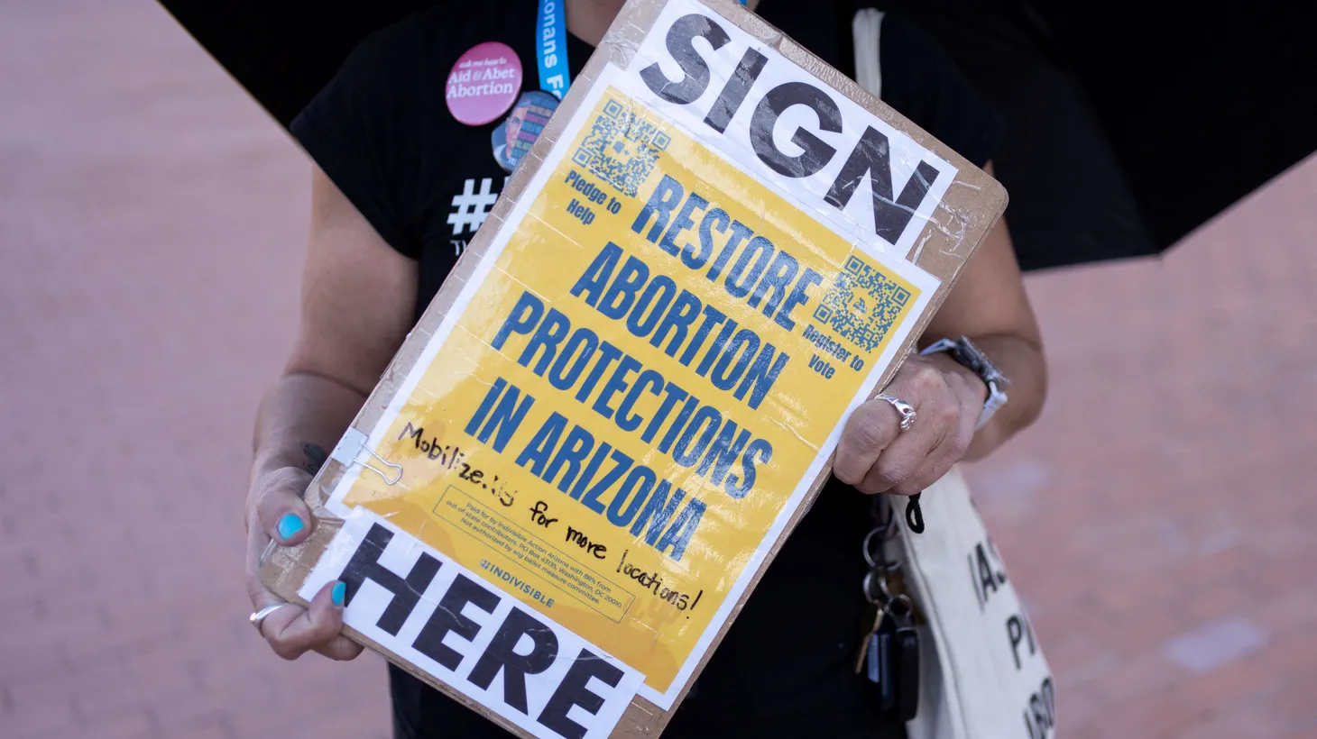 An organizer carries a clipboard with petitions for a ballot initiative to enshrine abortion into the Arizona state constitution during a small rally led by Women's March Tucson after Arizona's Supreme Court revived a law dating to 1864 that bans abortion in virtually all instances, in Tucson, Arizona, U.S. April 9, 2024.