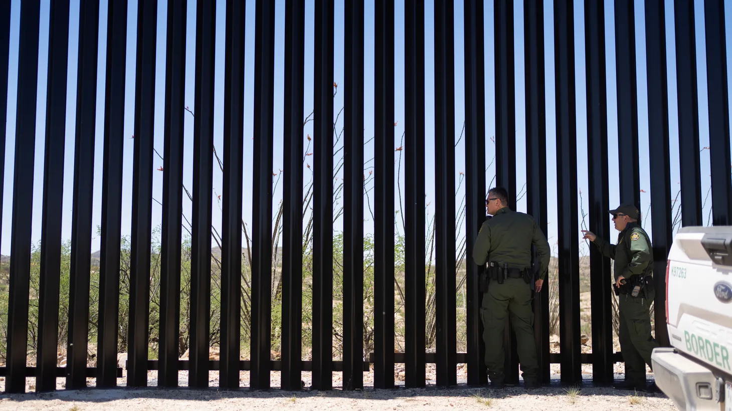 U.S. Customs and Border Protection agent and public information officer Jesus Vasavilbaso, center right, and supervisory agent Carlos Ruiz, right, look for members of the Mexico National Guard Performing a mirror patrol on the other side of the U.S.-Mexico border near Sasabe, Arizona, U.S., May 10, 2022.