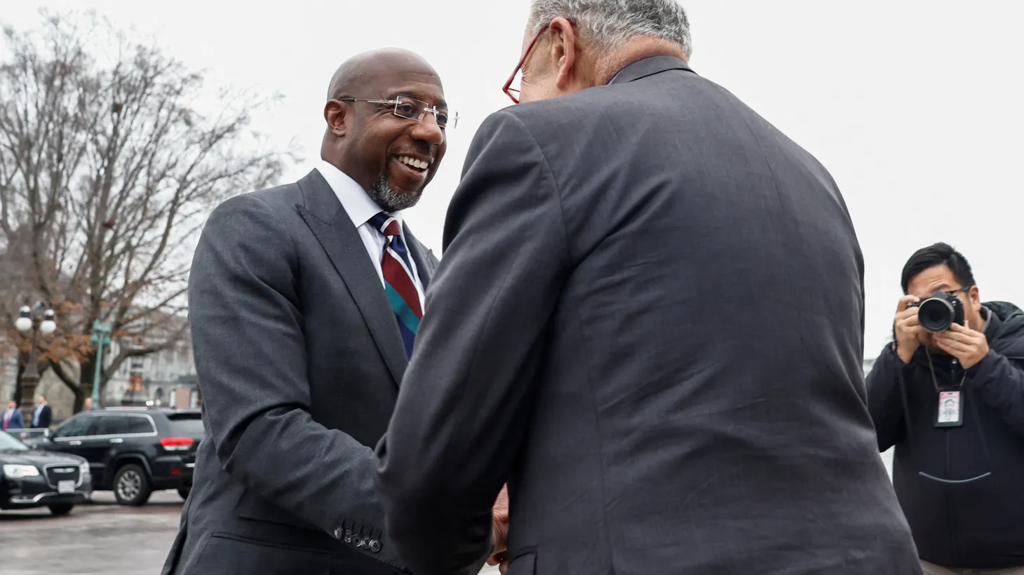 U.S. Senator Raphael Warnock (D-GA) is greeted by Senate Majority Leader Chuck Schumer (D-NY) at the Senate steps of the U.S. Capitol on Capitol Hill as Warnock returns to the Senate one day after defeating Republican challenger Herschel Walker in a Georgia runoff, in Washington, U.S., December 7, 2022.