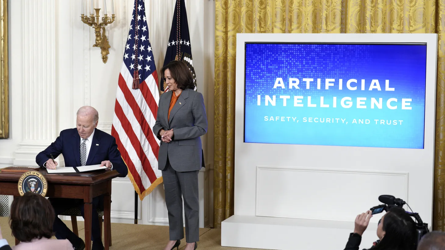 U.S. President Joe Biden, with Vice President Kamala Harris, signs an executive order during the artificial intelligence event at the White House on October 30, 2023.