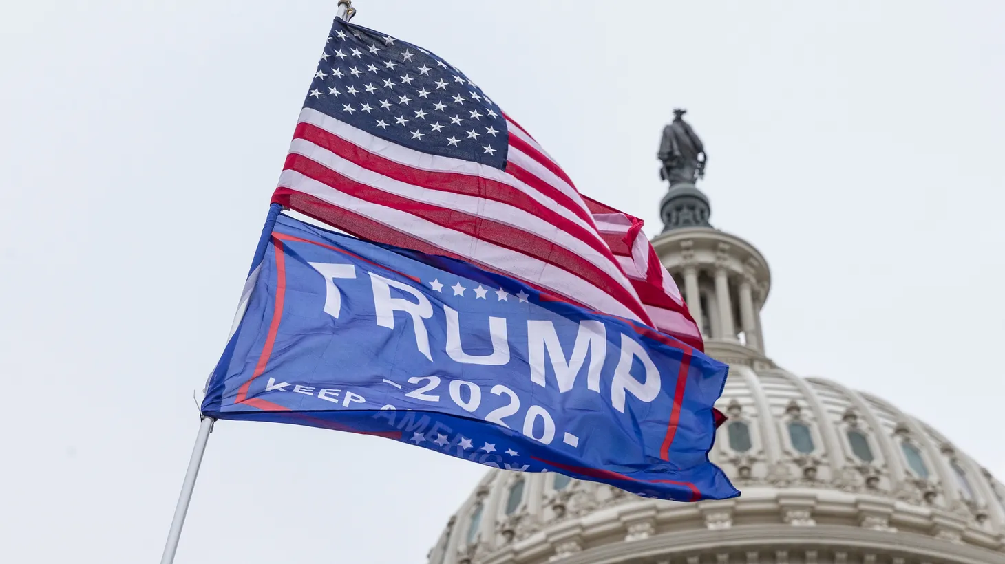USA and Trump 2020 flags fly on the same pole during the January 6 attack on the U.S. Capitol in Washington, D.C., U.S., January 6, 2021.